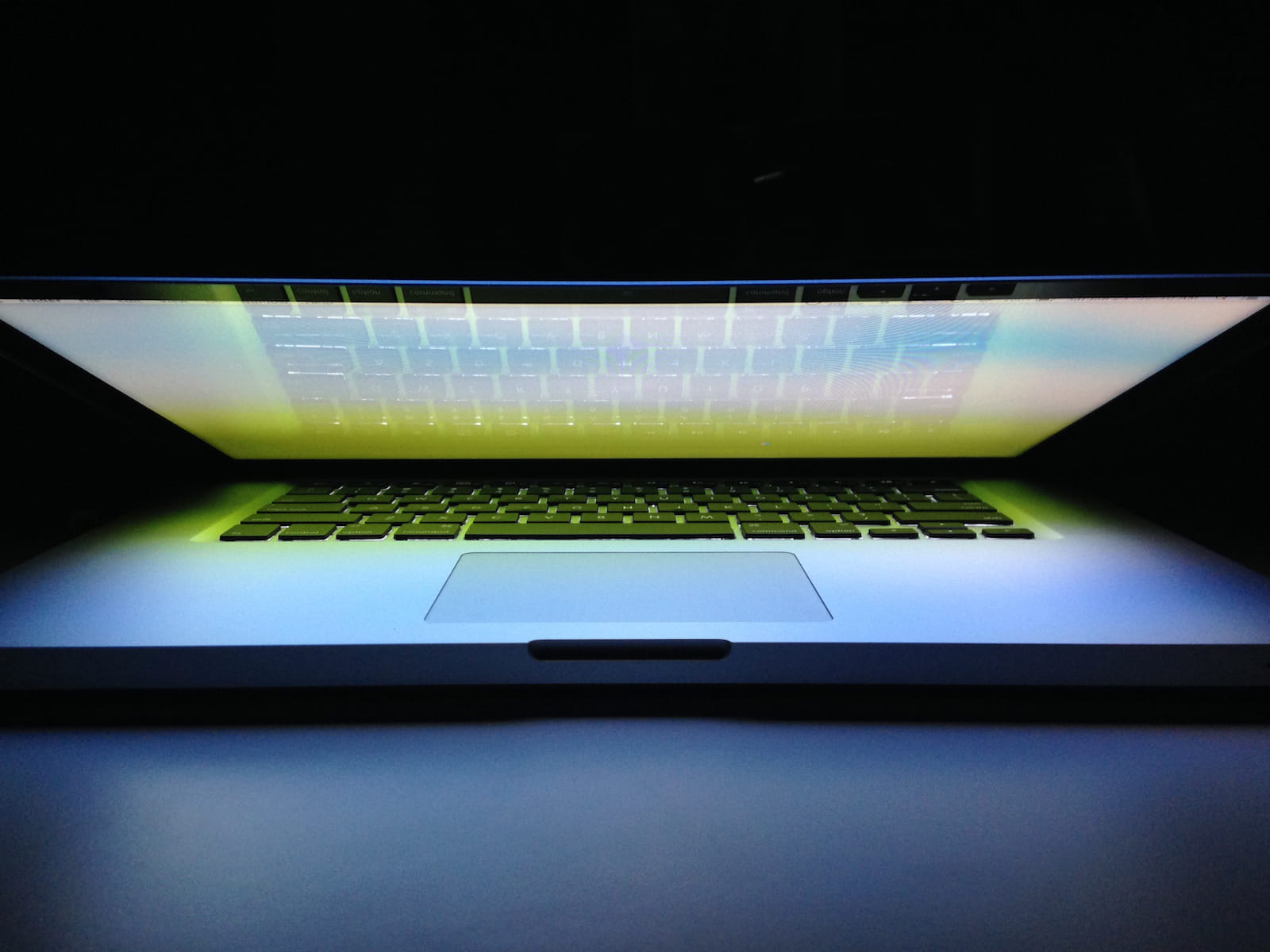 Laptop backlight glowing brightly in a dark room